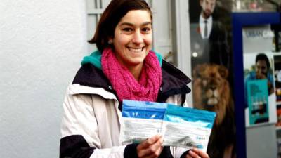Una joven fue registrada el pasado miércoles al mostrar dos paquetes de cinco gramos de marihuana de uso recreativo, frente a una farmacia que empezaron su comercialización legal, en Montevideo (Uruguay). EFE