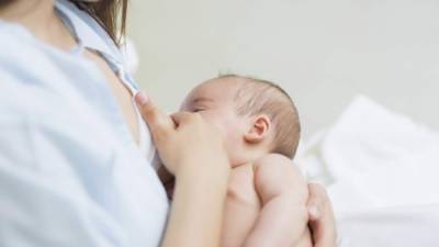 Mother breastfeeding a new born baby boy in a hospital room