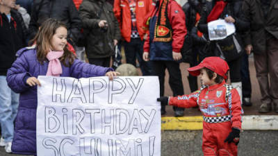 Dos niños sujetan un cartel en el que felicitan al expiloto alemán Michael Schumacher por su 45 cumpleaños, frente al hospital francés de Grenoble en el que permando, hoy, viernes 3 de enero de 2014.