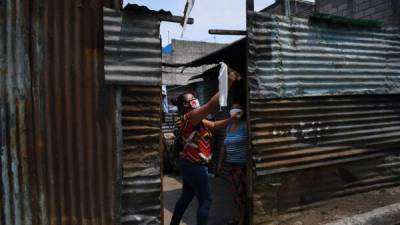 Las familias guatemaltecas que ya no tienen alimentos colocan banderas en sus puertas para pedir ayuda./AFP.