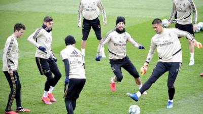 (FILES) In this file photo taken on February 29, 2020 Real Madrid's Spanish defender Sergio Ramos (C) challenges Real Madrid's French goalkeeper Alphonse Areola (R) next to other teammates during a training session at the club's training ground in Valdebebas in the outskirts of Madrid on February 29, 2020 on the eve of the Spanish League football match between Real Madrid and Barcelona. - Real Madrid went into quarantine on March 12, 2020 as La Liga announced Spain's top two divisions will be suspended for at least two weeks over the coronavirus. (Photo by JAVIER SORIANO / AFP)