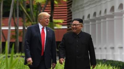 TOPSHOT - North Korea's leader Kim Jong Un (R) walks with US President Donald Trump (L) during a break in talks at their historic US-North Korea summit, at the Capella Hotel on Sentosa island in Singapore on June 12, 2018.Donald Trump and Kim Jong Un became on June 12 the first sitting US and North Korean leaders to meet, shake hands and negotiate to end a decades-old nuclear stand-off. / AFP PHOTO / SAUL LOEB