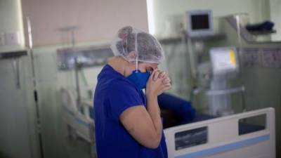 Una enfermera ora por los pacientes en cuidados intensivos en un hospital de Salvador, Brasil./AFP.