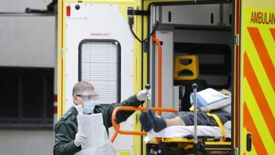 Un miembro de los servicios de ambulancia ayuda a trasladar a un paciente de una ambulancia al Hospital St Thomas 'en Londres hoy 31 de marzo de 2020, ya que el país está bajo cierre debido a la nueva pandemia de coronavirus COVID-19.Tolga AKMEN / AFP