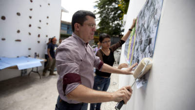 El director del Centro Cultural de España en Tegucigalpa (CCET), Álvaro Ortega, participa en la instalación del mural colectivo. Fotografía de EFE.