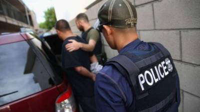 This image released by the US Immigration and Customs Enforcement (ICE) shows a Homeland Security Investigations (HSI) officer guarding suspected illegal aliens on August 7, 2019. Officers detained approximately 680 aliens who were unlawfully working at at seven agricultural processing plants across Mississippi. - US officials said that some 680 undocumented migrants were detained in a major series of raids on August 7, at food processing plants in the southeastern state of Mississippi, part of President Donald Trump's announced crackdown on illegal immigration. 'Special agents executed administrative and criminal search warrants resulting in the detention of approximately 680 illegal aliens,' said Mike Hurst, US Attorney for the Southern District of Mississippi. (Photo by HO / US Immigration and Customs Enforcement / AFP) / RESTRICTED TO EDITORIAL USE - MANDATORY CREDIT 'AFP PHOTO / US Immigration and Customs Enforcement' - NO MARKETING NO ADVERTISING CAMPAIGNS - DISTRIBUTED AS A SERVICE TO CLIENTS