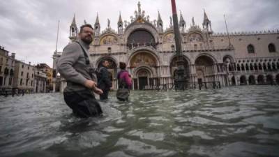 Una vista general muestra hoy a personas caminando a través de la inundada Plaza de San Marcos, junto a la Basílica de San Marcos en Venecia, dos días después de que la ciudad sufriera su marea más alta en 50 años.