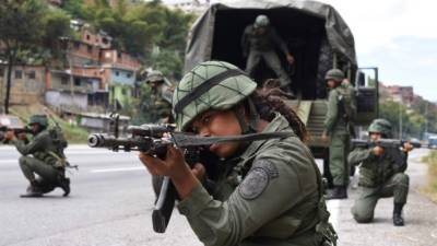 A member of 311 mechanized infantry battalion Liberator Simon Bolivar points his Ak 103 rifle next to a 120mm mortar during military exercises for the 'Bolivarian Shield 2020 Operation' in Caracas, on February 15, 2020. - The Venezuelan Armed Forces fulfilled Saturday, the first of two days of military exercises in preparation of alleged aggression plans from the United States, Colombia and Brazil, according to Venezuelan government. (Photo by Yuri CORTEZ / AFP)