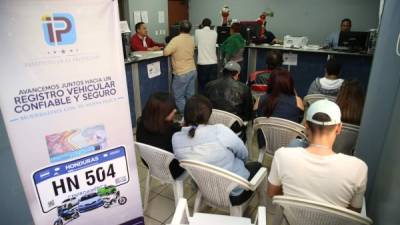 Personas pagando su registro vehicular en el IP. Archivo