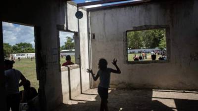 Niños juegan en una estructura abandonada cerca de un campo de fútbol en la Rivera Hernández. Foto: The New York Times