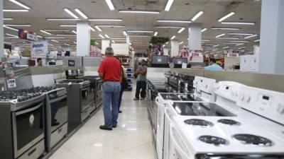 Usuarios observan los productos de línea blanca que ofrece una tienda por departamentos en San Pedro Sula. Foto: Franklyn Muñoz