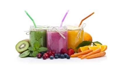 Front view of three blended fruit smoothies surrounded by colorful fresh fruits isolated on white background. DSRL studio photo taken with Canon EOS 5D Mk II and Canon EF 100mm f/2.8L Macro IS USM