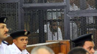 Imagen de un acusado no identificado tras los barrotes durante un juicio por asesinato de un alto cargo de la policía el año pasado, en Giza (Egipto), este 18 de junio. EFE