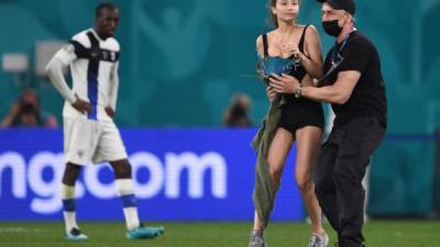 Una chica ha sorprendido en la jornada de este lunes en la Eurocopa al invadir el terreno de las acciones en el duelo Finlandia vs Bélgica. Fotos AFP y EFE.