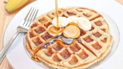 Los waffles acompañados con miel y banano es una cambinación perfecta.