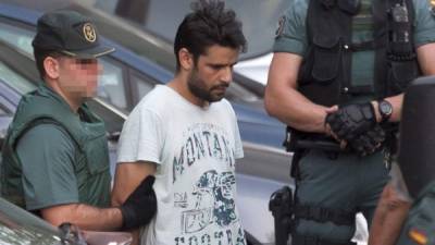 Mohamed Aallaa, suspected of involvement in the terror cell that carried out twin attacks in Spain, is escorded by Spanish Civil Guards from a detention center in Tres Cantos, near Madrid, on August 22, 2017 before being tranferred to the National Court.Under heavy security, police vans entered the National Court, which deals with terrorism cases, where a judge will question them and decide what -- if any -- charges to press against them over the vehicle attacks that left 15 dead and 120 injured. / AFP PHOTO / STRINGER