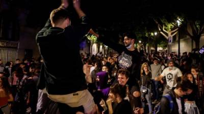 Miles de jóvenes salieron esta madrugada a las calles y plazas de las grandes ciudades españolas para celebrar el fin del estado de alarma, sin medidas de seguridad contra la pandemia, lo que obligó a actuar a la policía en muchas ocasiones.