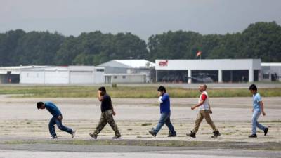 En la imagen, deportados guatemaltecos caminan de regreso a su país al bajar de un avión. EFE/Archivo