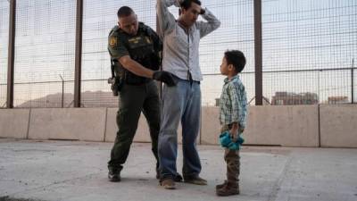 Un agente de Aduanas y Protección Fronteriza de los Estados Unidos en El Paso, Texas, registra a un inmigrante y su hijo de 6 años. Foto AFP