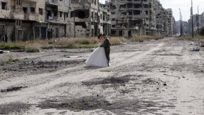 Una joven pareja conformada por un soldado del ejército sirio de Bachar al Assad y su novia, decidieron realizar las fotografías de su boda en los escombros de la ciudad siria de Homs. Fotos AFP.