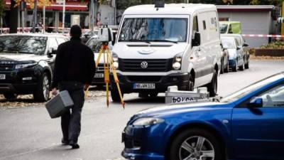 Agentes de policía inspeccionan el escenario donde una furgoneta que transportaba dinero y objetos de valor fue atracada hoy en la plaza Alexanderplatz, en Berlín (Alemania). EFE