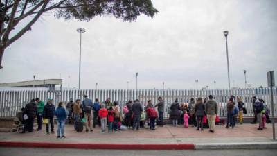 Un grupo de migrantes esperan para iniciar la solicitud de visa humanitaria afuera de la oficina fronteriza estadounidense de El Chaparral. EFE/Archivo