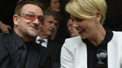 Bono y Charlize Theron platican en el servicio religioso de Nelson Mandela.