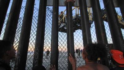 Migrantes de la primera caravana, que salió desde honduras y recorrió el territorio mexicano, comienzan a congregarse en la valla fronteriza de Tijuana (México). EFE