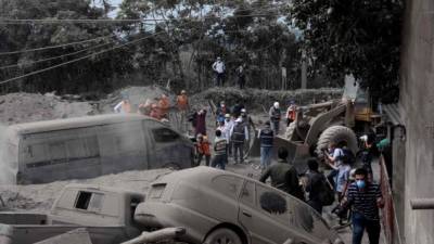 Rescuers search for victims in the village of San Miguel Los Lotes, in Escuintla department, about 35 km southwest of Guatemala City, two days after the eruption of the Fuego Volcano, on June 5, 2018.Rescue workers pulled more bodies from under the dust and rubble left by an explosive eruption of Guatemala's Fuego volcano, bringing the death toll to at least 69. / AFP PHOTO / JOHAN ORDONEZ