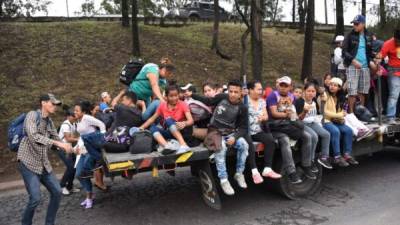 Honduran migrants aboard vehicles head in a caravan to the United States, in Guatemala City, on October 18, 2018. - US President Donald Trump threatened Thursday to send the military to close its southern border if Mexico fails to stem the 'onslaught' of migrants from Central America, in a series of tweets that blamed Democrats ahead of the midterm elections. (Photo by JOHAN ORDONEZ / AFP)