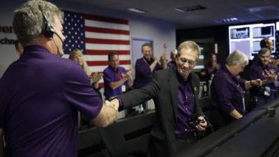 Cassini Project Manager Earl Maize (R) shakes hands with Bill Heventhal in mission control at NASA's Jet Propulsion Laboratory September 15, 2017, after confirmation of Cassini's demise.After 20 years in space, NASA's famed Cassini spacecraft made its final death plunge into Saturn, ending a storied mission that scientists say taught us nearly everything we know about Saturn today and transformed the way we think about life elsewhere in the solar system. / AFP PHOTO / POOL / Jae C. Hong