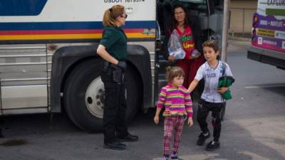 Immigrants are dropped off at a bus station shortly after being released from detention through 'catch and release' immigration policy on June 17, 2018 in McAllen, Texas. 'Catch and release' is a protocol under which people detained by US authorities as unlawful immigrants can be released while they wait for a hearing. / AFP PHOTO / Loren ELLIOTT