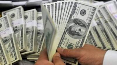 Un joven cuenta dólares en una sucursal bancaria de Miami, Estados Unidos.