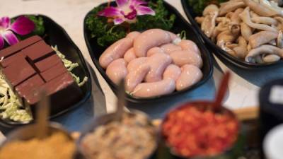Una fotografía muestra platos de cubos de sangre de pato (izda), testículos de pollo (c) e intestinos de cerdo (dcha) en un restaurante de olla caliente en Hong Kong, China. EFE