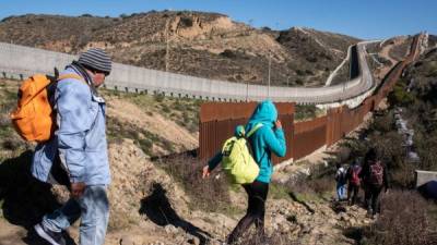 A group of Central American migrants look for a spot to cross the US-Mexico border fence from Tijuana, Baja California State, Mexico, into the US, on December 30, 2018. - Outgoing White House chief John Kelly said he had 'nothing but compassion' for undocumented migrants crossing into the US and undercut the idea of a border wall in an interview published Sunday that jarred with President Donald Trump's rhetoric on immigration. (Photo by GUILLERMO ARIAS / AFP)