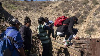 Decenas de familias hondureñas cruzan a diario el muro entre México y Estados Unidos.