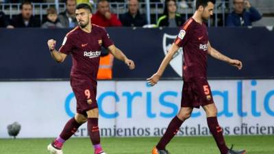 GRAF9355. MÁLAGA, 10/03/2018.- Los jugadores del FC Barcelona, el delantero uruguayo Luis Suárez (i) y el centrocampista Sergio Busquets, celebran el gol marcado por Suárez ante el Málaga, durante el partido de esta noche en el Estadio La Rosaleda de Málaga, correspondiente a la jornada 28 de LaLiga. EFE/ Daniel Pérez