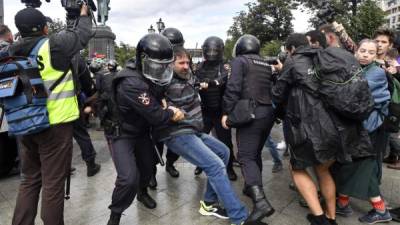 Agentes de la policía antidisturbios detienen a un participante de una manifestación no autorizada que insta a elecciones justas en la Plaza Pushkinskaya de Moscú.