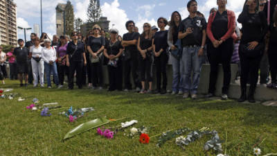 .- Varias personas colocan unas flores sobre el pasto durante una convocatoria hoy, domingo 12 de enero de 2013, en Caracas (venezuela). AFP