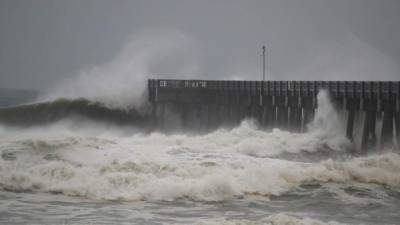 PANAMA CITY BEACH, FL - OCTOBER 10: Waves crash along a pier as the outerbands of hurricane Michael arrive on October 10, 2018 in Panama City Beach, Florida. The hurricane is forecast to hit the Florida Panhandle at a possible category 4 storm. Joe Raedle/Getty Images/AFP