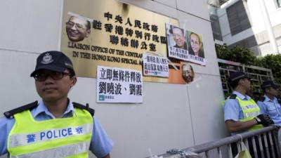 Vista de máscaras con la cara del disidente chino y ganador del Premio Nobel, Liu Xiaobo, colocadas hoy, martes 27 de junio de 2017, en una pared de la Oficina de Enlace de China en Hong Kong (China). EFE