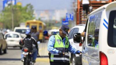 Un agente hondureño revisa una unidad del transporte público. Foto de archivo.