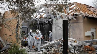 Policías inspeccionan una casa dañada tras impactar un cohete lanzado desde la Franja de Gaza en la comunidad de Mishmeret, en la región central de Israel, este lunes. EFE