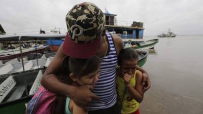 Un padre y sus hijas son evacuados de Nicaragua ante la inminente llegada de Otto. AFP.