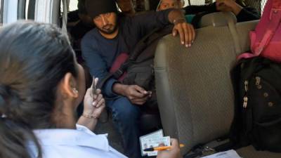 A Central American migrant family waits inside a van after being detained by members of the Mexican National Guard and officers of the Migration Institute, in Ciudad Hidalgo, Chiapas State, Mexico, on January 22, 2020. - The Mexican government tried to dialogue with the new caravan of Central Americans on Tuesday to prevent their irregularly entering and instead take a refuge and temporary employment programs in the south of the country. (Photo by ALFREDO ESTRELLA / AFP)