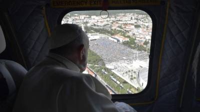 This handout photo taken on May 12, 2017 and released by the Vatican press office, the Osservatore Romano, shows Pope Francis looking at Fatima shrine from the helicopter window moments before arriving at the Fatima sanctuary, in central PortugalTwo of the three child shepherds who reported apparitions of the Virgin Mary in Fatima, Portugal, one century ago, will be declared saints on May 13, 2017 by Pope Francis.The canonisation of Jacinta and Francisco Marto will take place during the Argentinian pontiff's visit to a Catholic shrine visited by millions of pilgrims every year. / AFP PHOTO / OSSERVATORE ROMANO / Handout