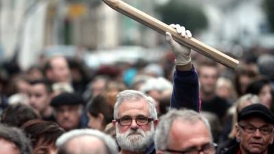 Un hombre sostiene un lápiz gigante durante una reunión en Tarbes, el sur de Francia, el 8 de enero de 2015, en homenaje a las 12 personas asesinadas el día anterior por dos hombres armados en la oficina del semanario satírico Charlie Hebdo.
