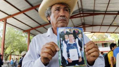 Un hombre muestra el retrato de su hijo, desaparecido el fin de semana.