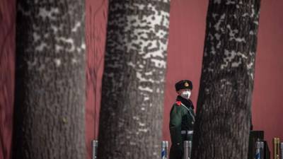 Un miembro del Ejército Popular de Liberación se protege con una mascarilla durante una guardia en la plaza de Tiananmen, en Pekín, China. EFE/EPA/ ROMAN PILIPEY