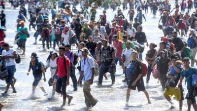 Central American migrants - mostly Hondurans travelling in caravan to the US- cross the Suchiate River, the natural border between , Guatemala, with Ciudad Hidalgo, Mexico, on January 20, 2020. - Hundreds of Central Americans from a new migrant caravan tried to enter Mexico by force Monday by crossing the river that divides the country from Guatemala, prompting the National Guard to fire tear gas, an AFP correspondent said. (Photo by Johan ORDONEZ / AFP)